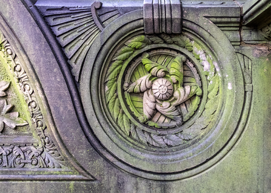 Circular stone carving on Capitol Hill features an intricate design with floral and leafy patterns